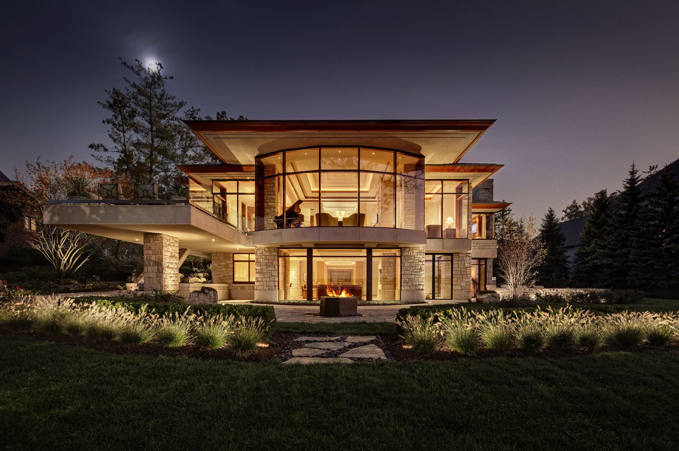 Luxury modern home with floor-to-ceiling window and glass door installation at dusk