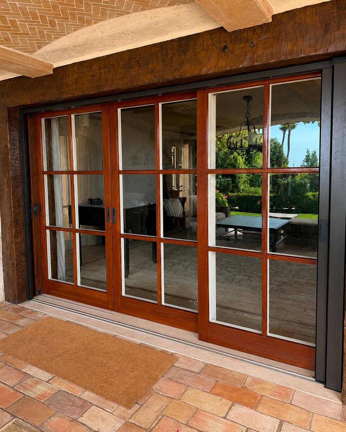 Wood-framed multi-panel sliding door open to a lawn and patio